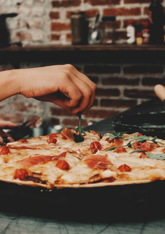 a pizza is being cut by the hand