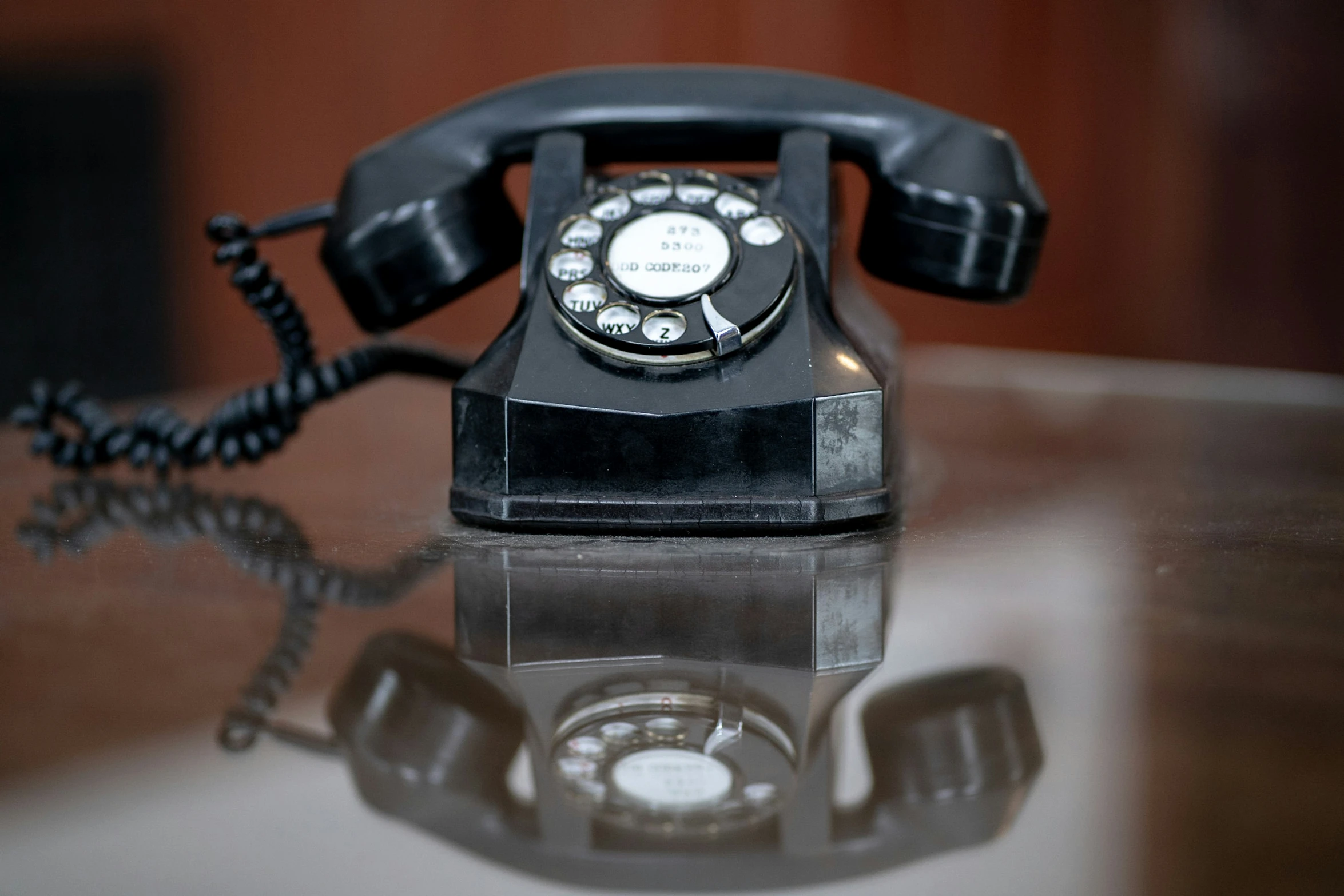 an old fashioned phone is on a shiny surface