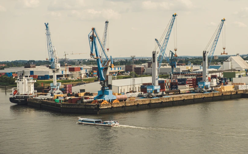 a boat is sitting in the water by cranes