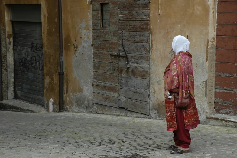 a woman with a head covering standing on the street