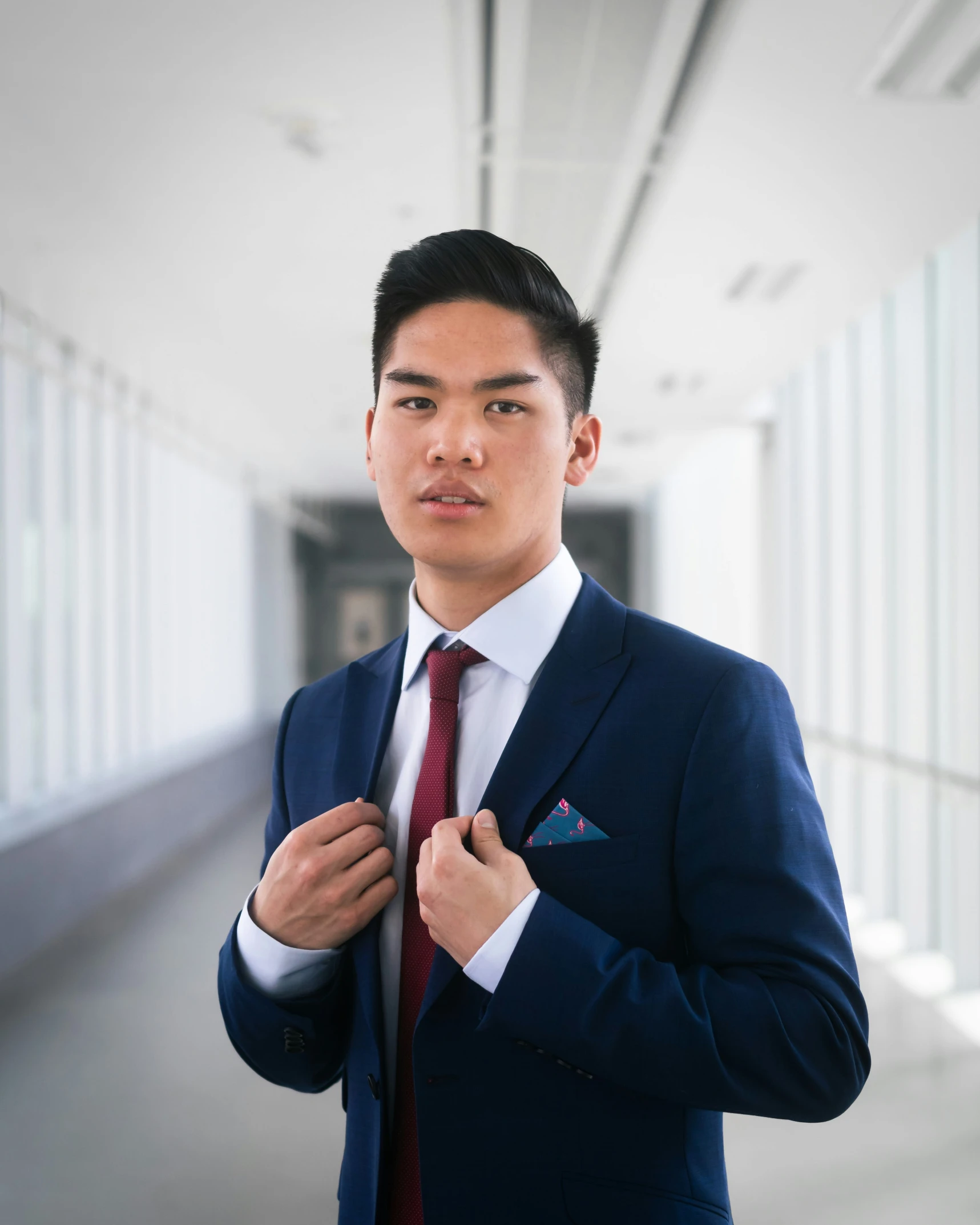 an asian man in a suit standing in a room