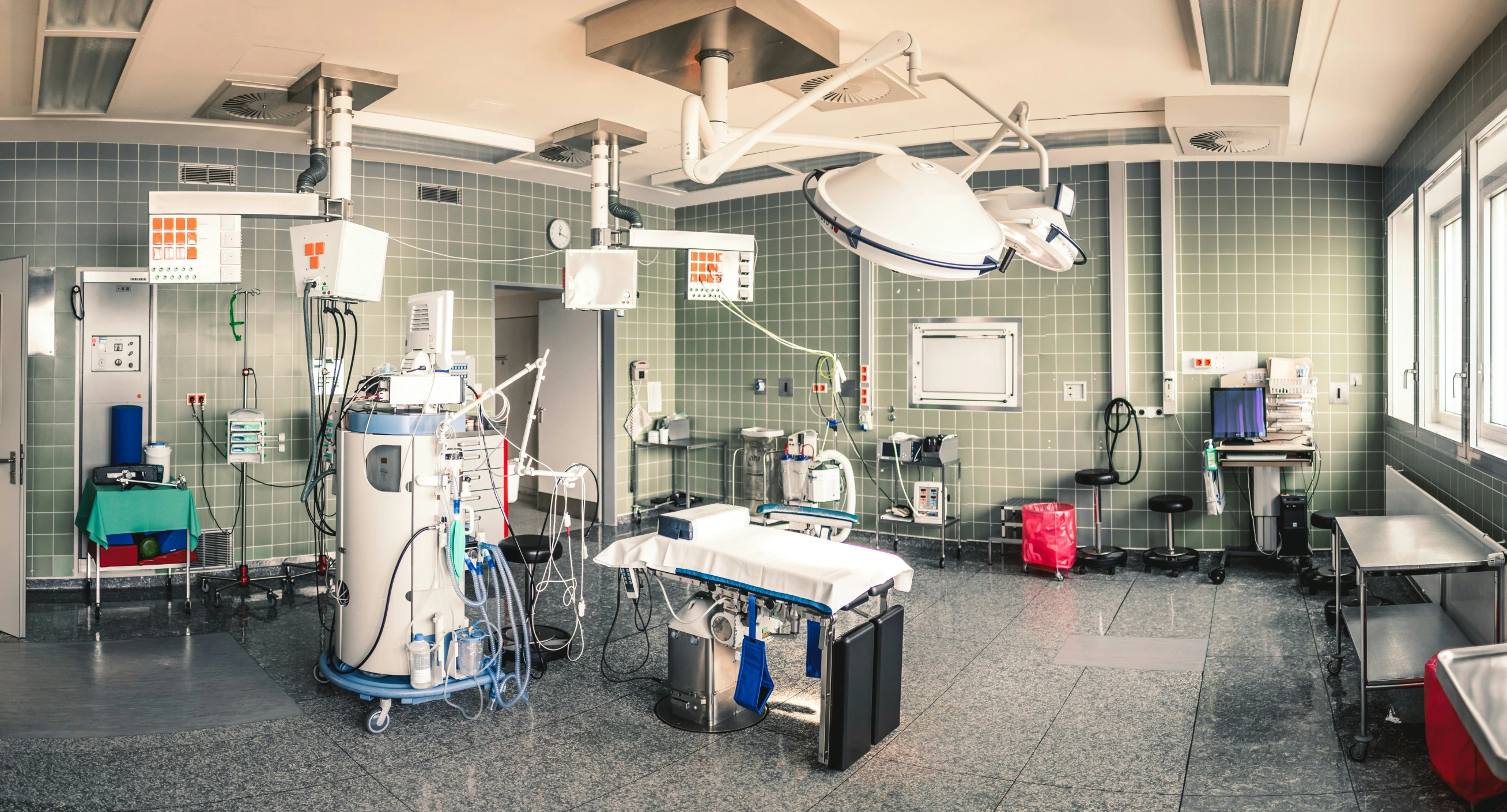 a surgical room with surgical equipment hanging on the wall