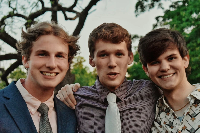 three young men in ties pose for the camera