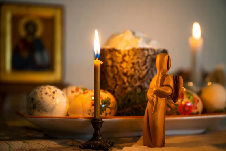 an old fashioned candle and small figurine are shown