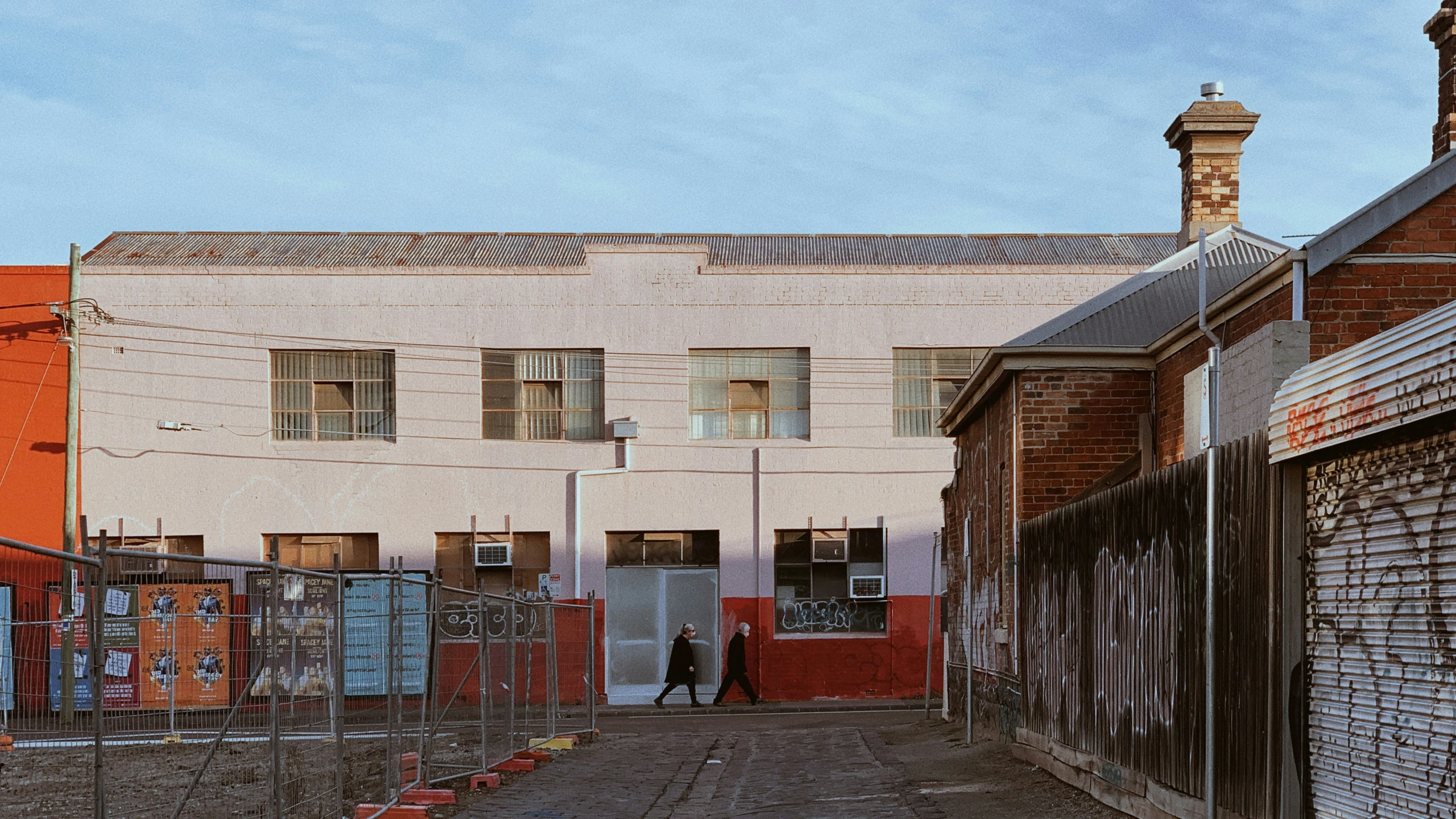 a man walks down an alleyway near some old buildings