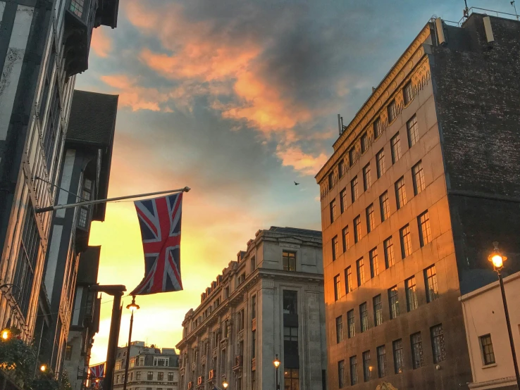 the sun is setting on an urban street