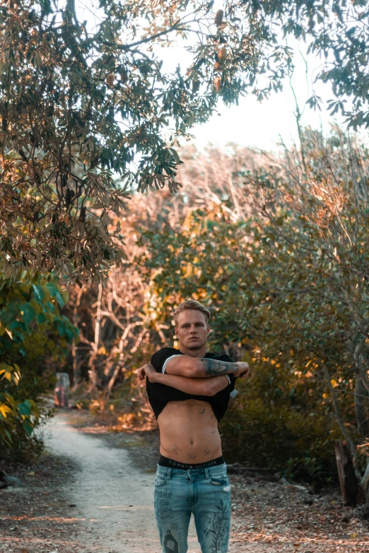 a man standing near trees is holding a baseball bat