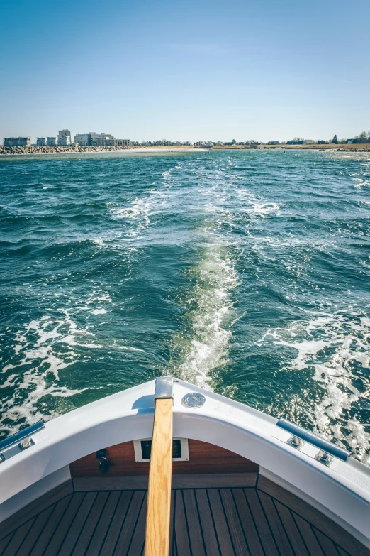 the boat is speeding along the water during the day