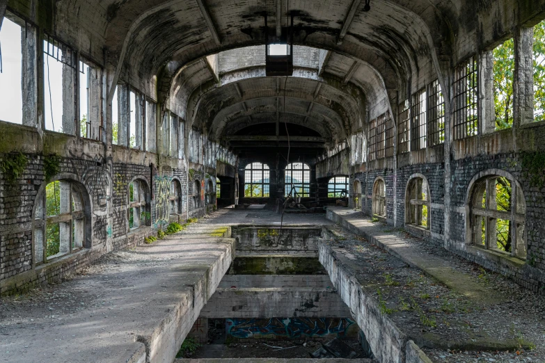 an abandoned building filled with windows and stone walls