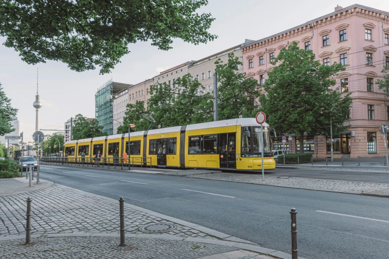 there is a yellow train that is riding through the city