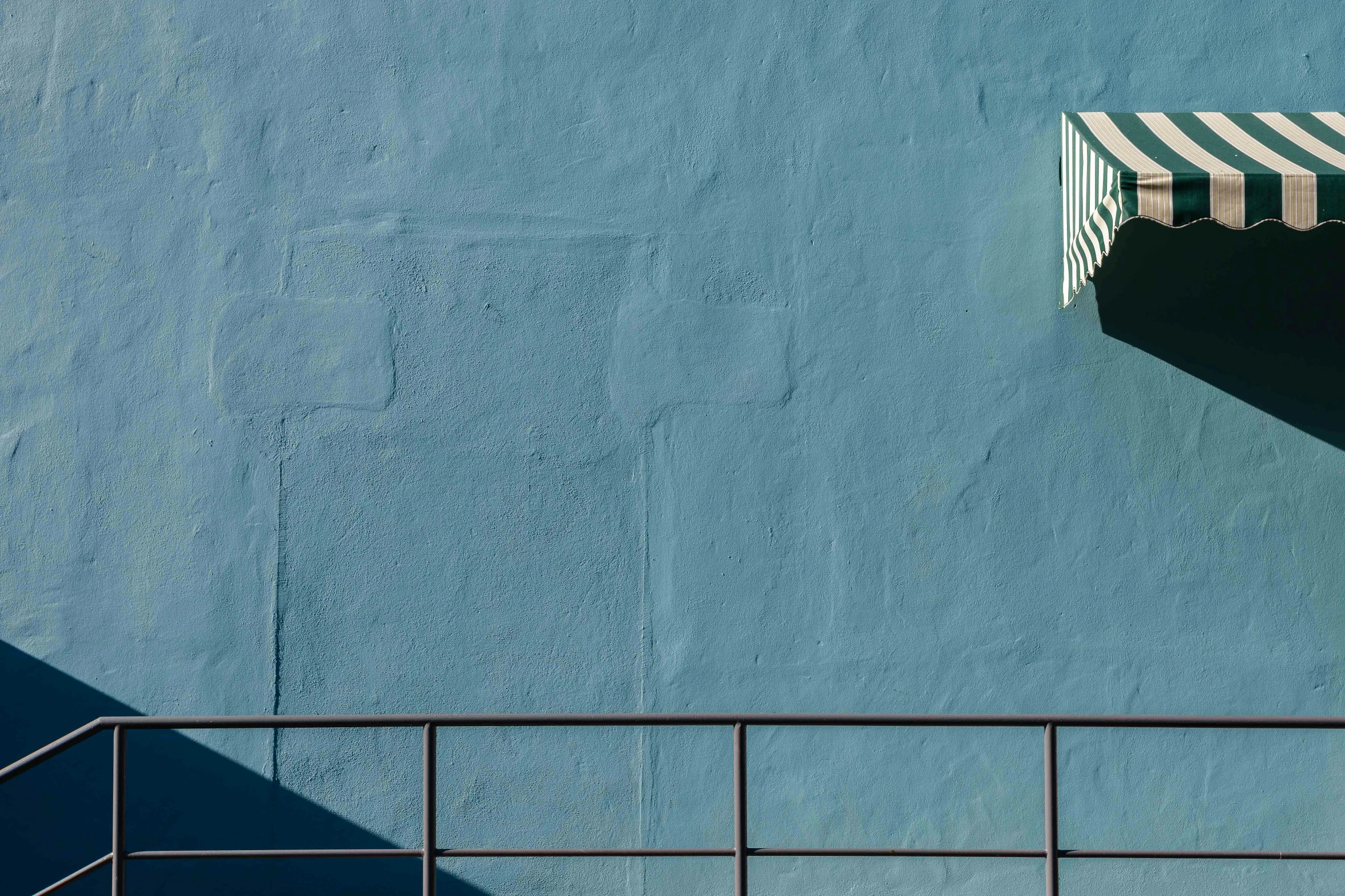 a fence and some blue wall with a window