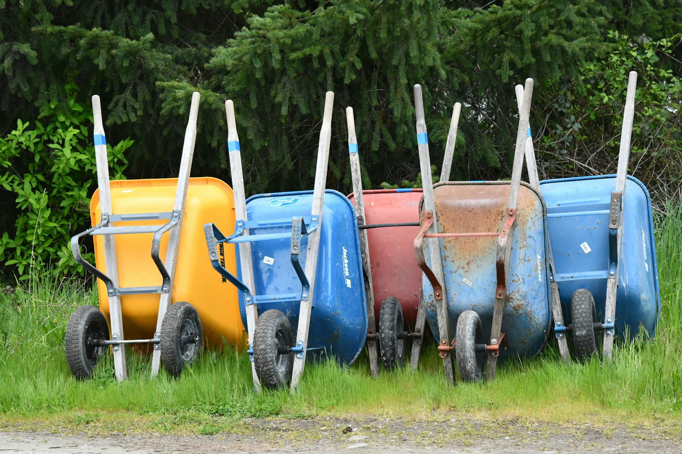 old wagon and bins in the grass next to each other