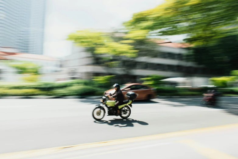 a person on a motor bike going through the street