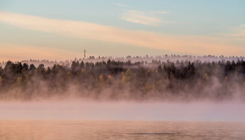 water is frozen by mist while a boat floats in the distance