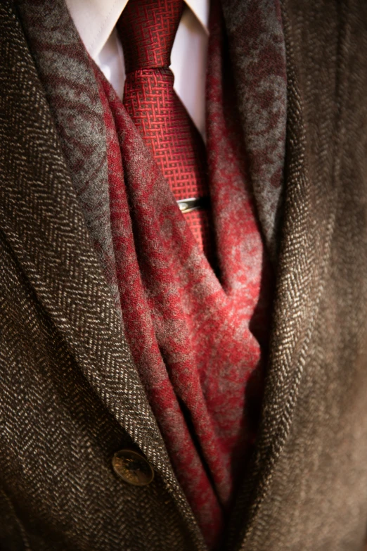 a close up of a man's suit with a tie and cardigan