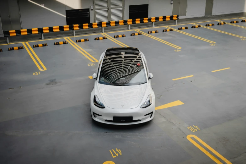 a white car is parked in an empty parking lot