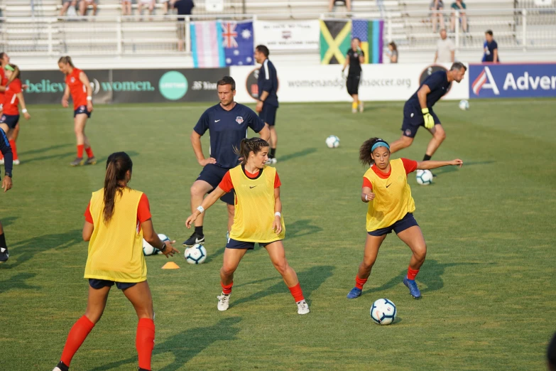 women are kicking around a soccer ball in the field