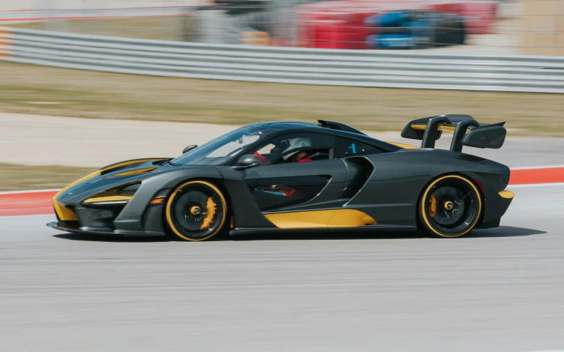 a yellow and grey car is in the motion of being driven