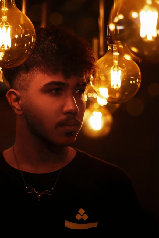 man standing in front of light bulb chandelier