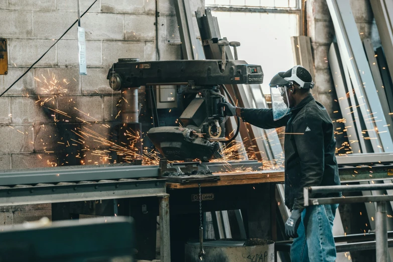 a man wearing safety glasses grinding metal with a grinder