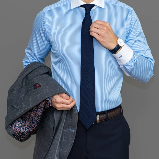 a man in a tie holding a blazer jacket