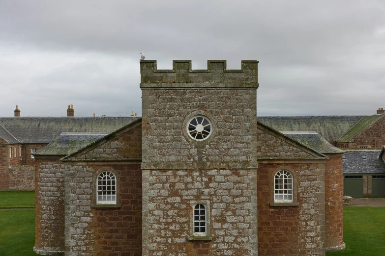 a stone building with a clock and windows