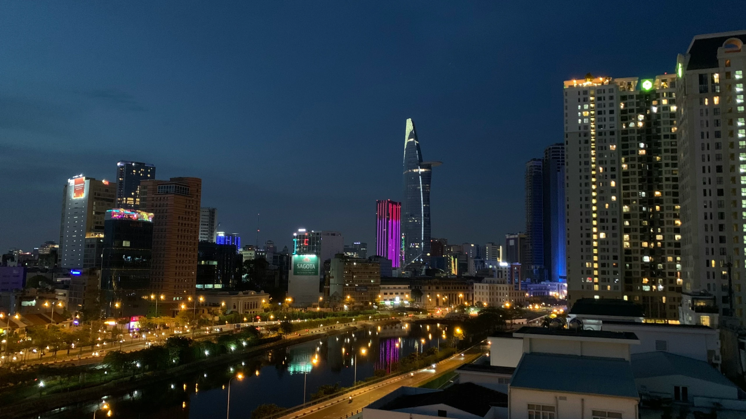 an aerial view of city at night, with a river running through it