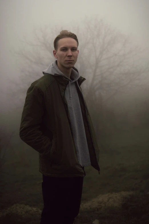 the man is standing on a foggy field