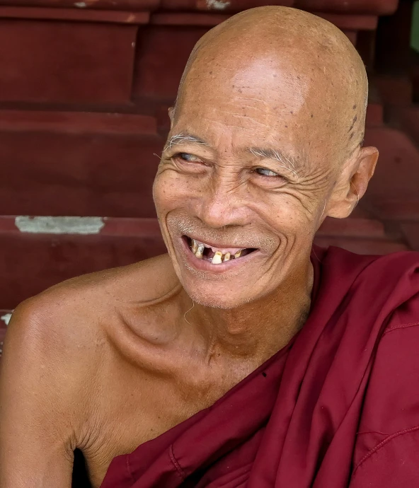 smiling monk with large open tooth in his left shoulder