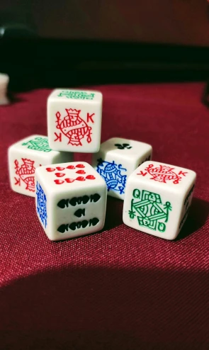 four dice sit on a pink tablecloth