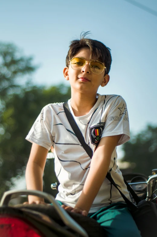 a boy on a bicycle wearing sunglasses and riding his bike