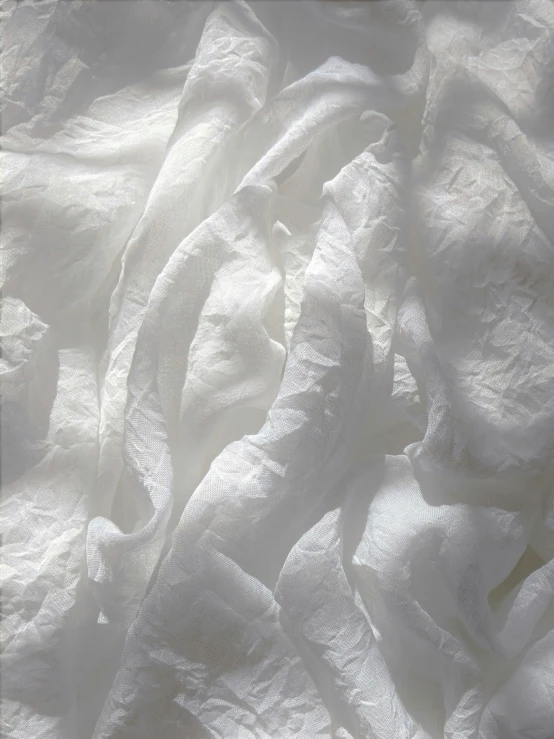 a white bed with sheer material that resembles white thread