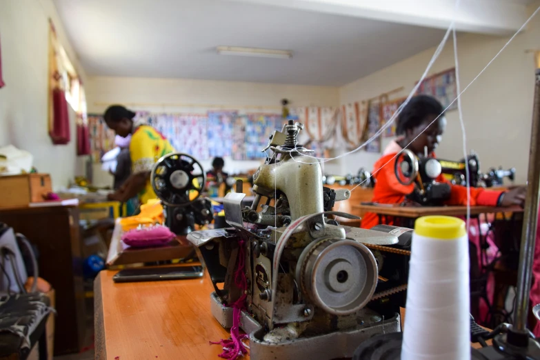 sewing machine in room with man and lady working on it