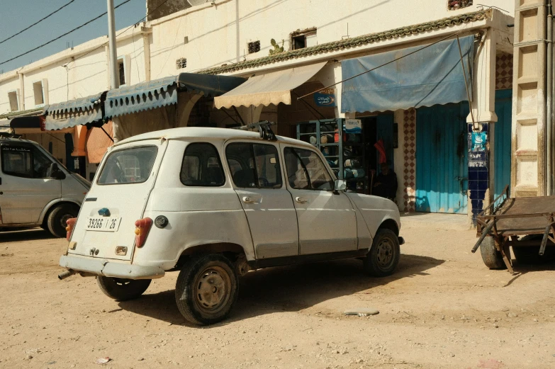 old van in the middle of road with buildings around