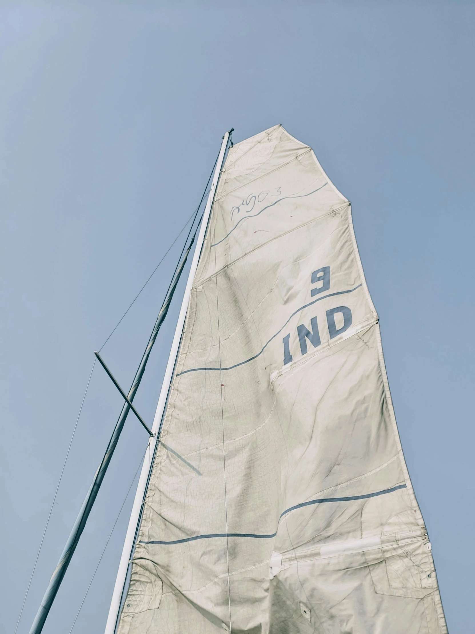 a sailboat is sailing under a clear blue sky