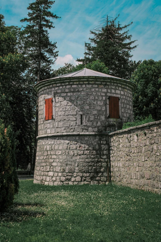 an old round brick building near a large wall