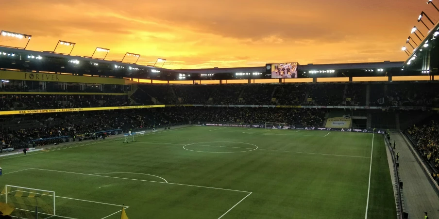 a view of the sun rising at a stadium