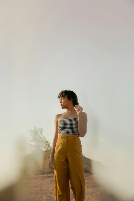 a woman is standing on a desert plain talking on her cellphone