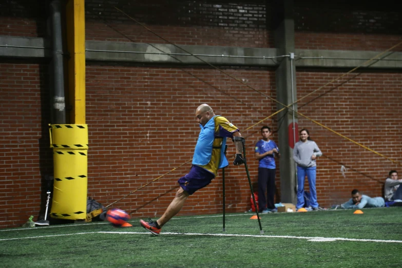 a man with two sticks is kicking a ball