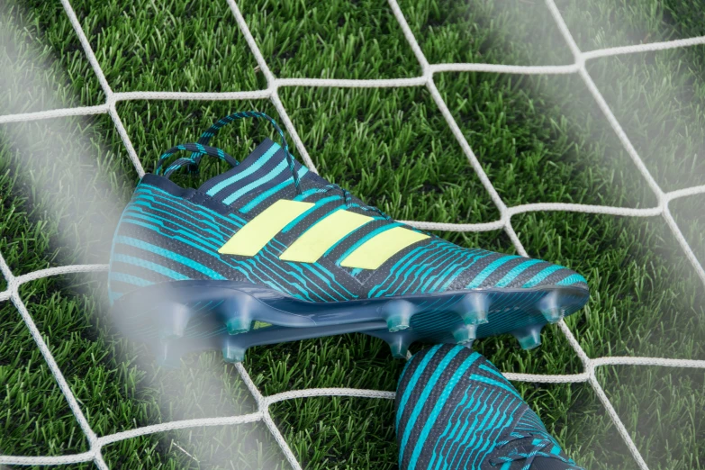 the blue and yellow football shoe is next to a net