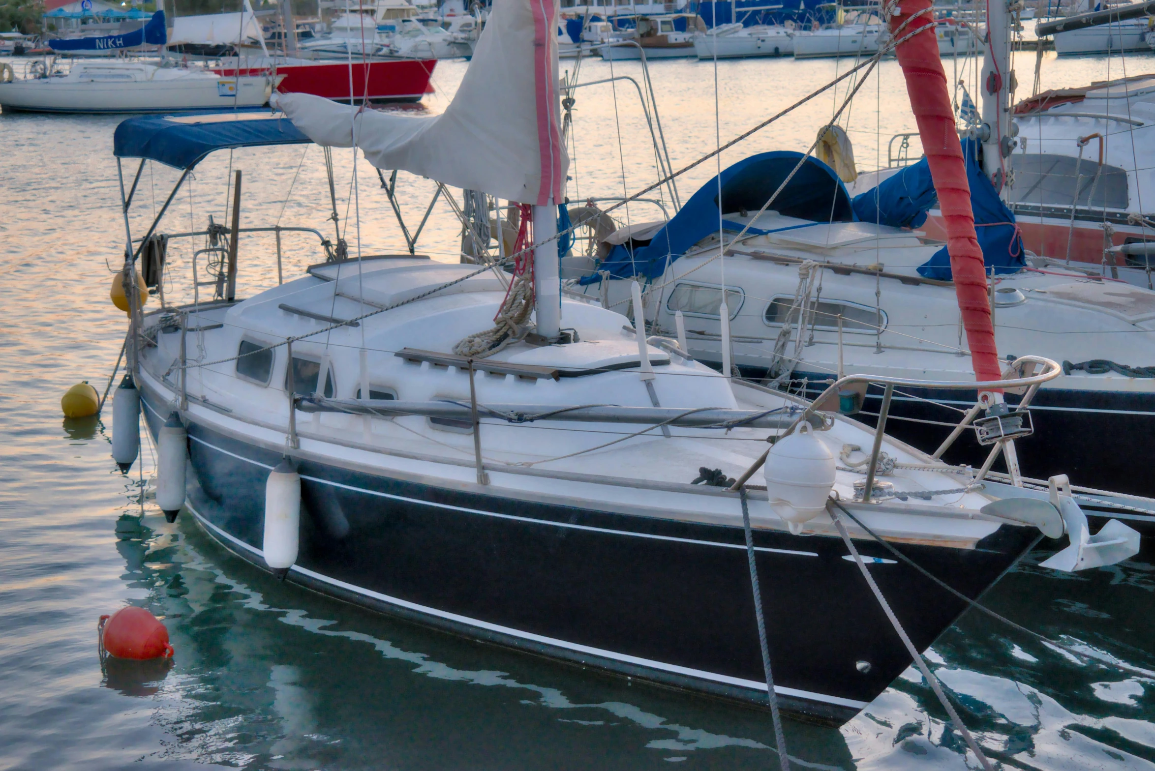 two sailboats are docked in the harbor of the city