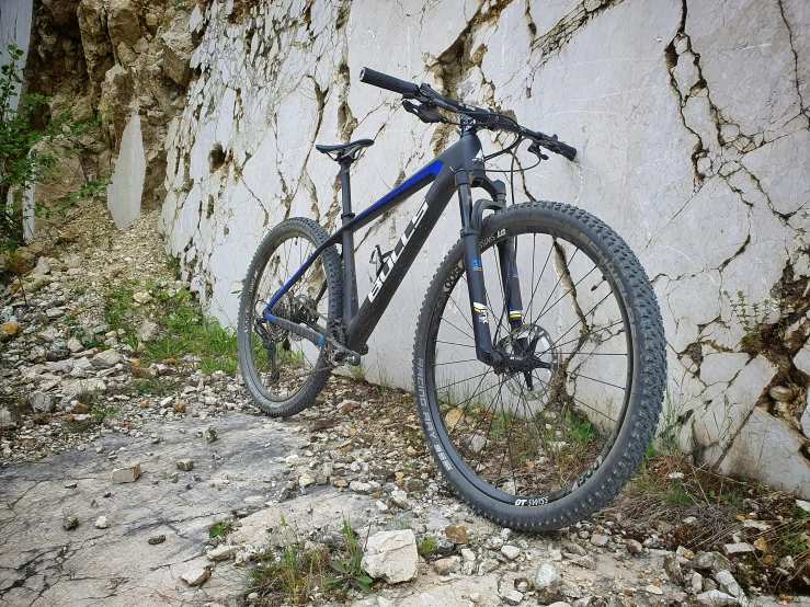 a bike sitting next to a big rock