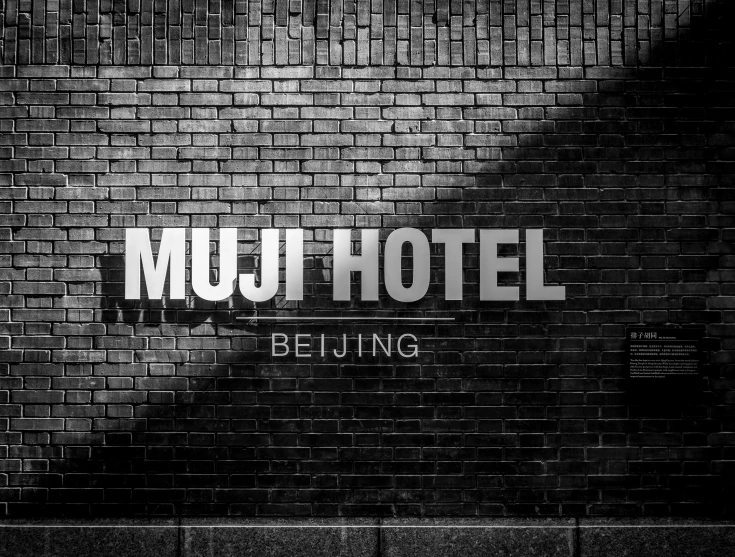 the words muju el being projected on a brick wall