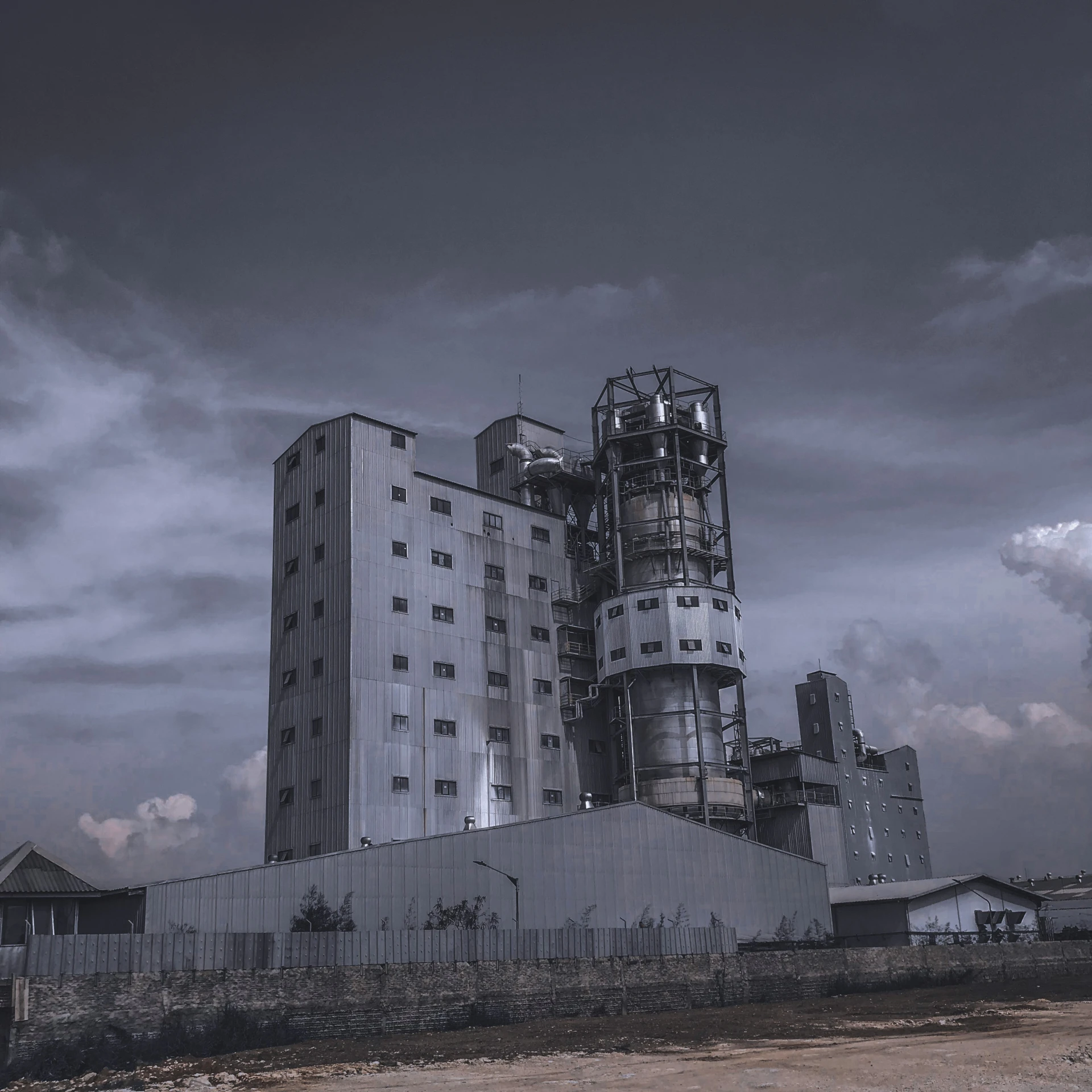 an old factory building stands in the middle of a field