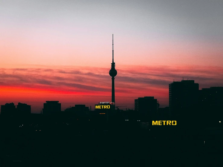 some buildings and a red and orange sky at dusk