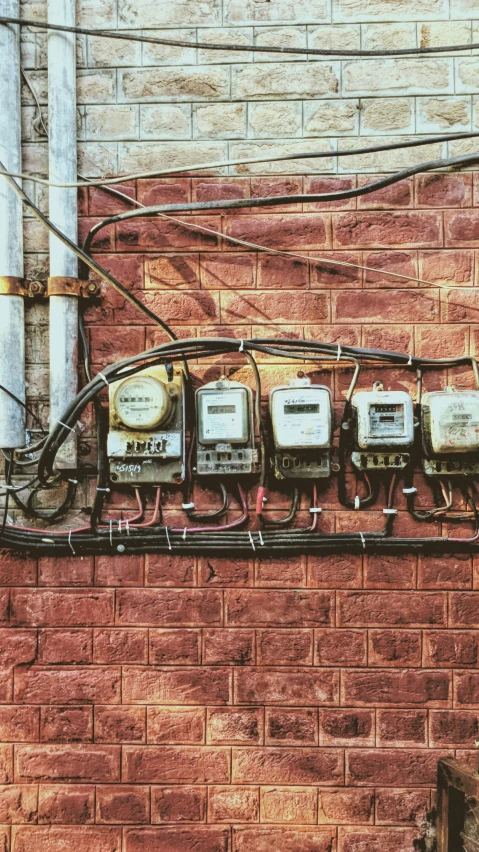 there are many phones mounted on a brick wall