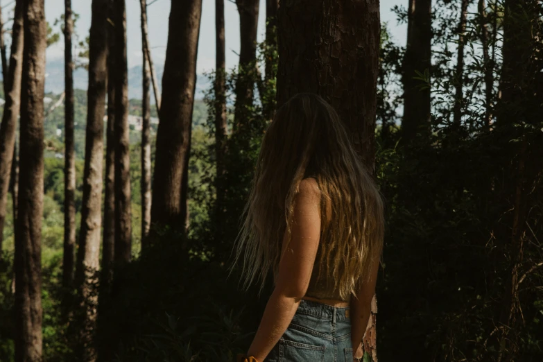 a girl with long hair walks in the forest