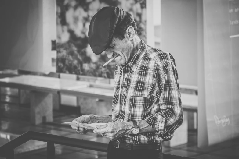 a black and white po of a man in a hat with a cigarette