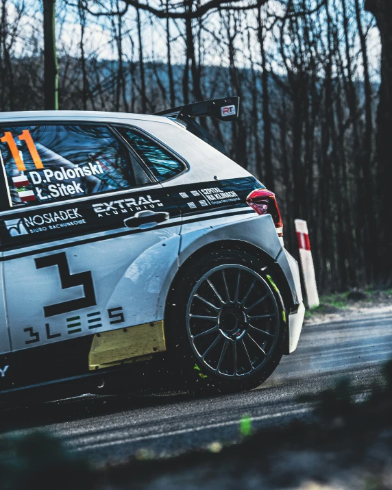 a grey and black race car driving on a road