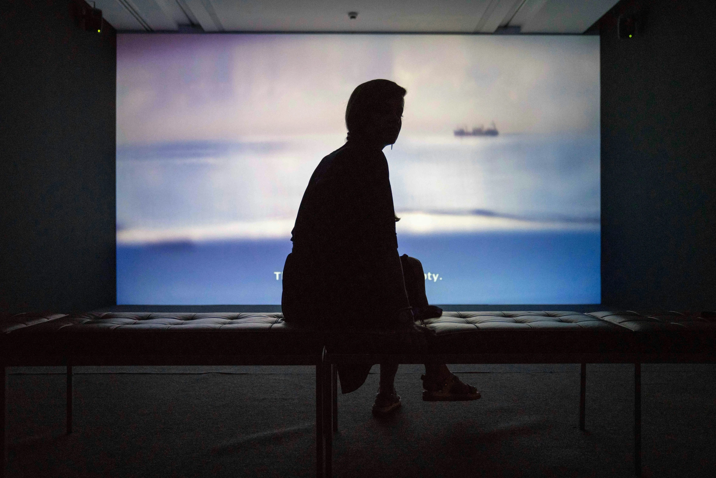 a person that is sitting in front of a large screen